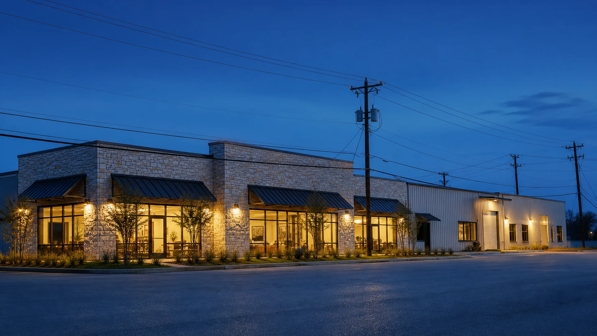 A Texas commercial strip fully lit and operating at dusk, with overhead distribution lines along the street